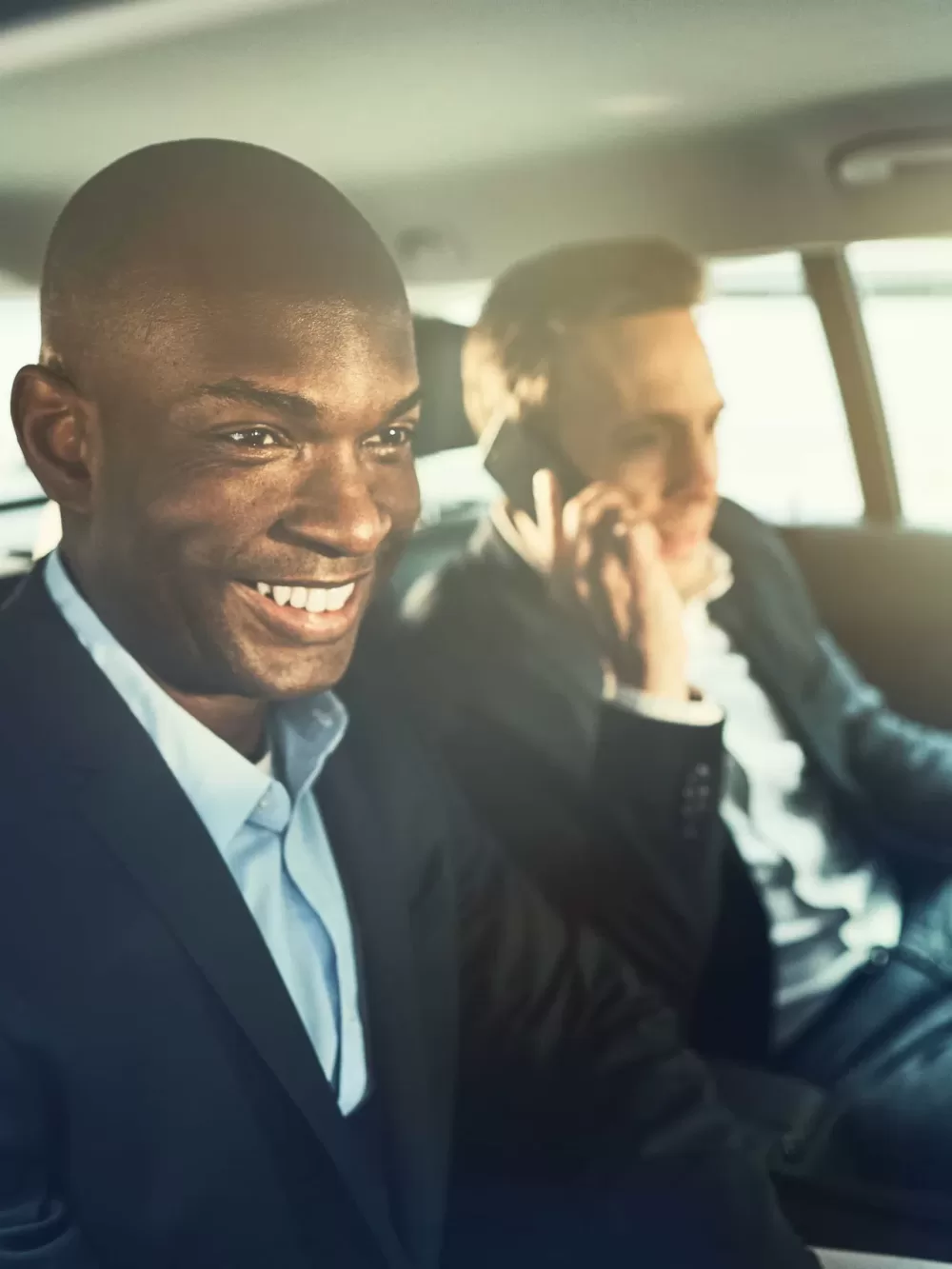 Taxi Latino Carxi smiling-african-businessman-driving-with-a-colleag (1)